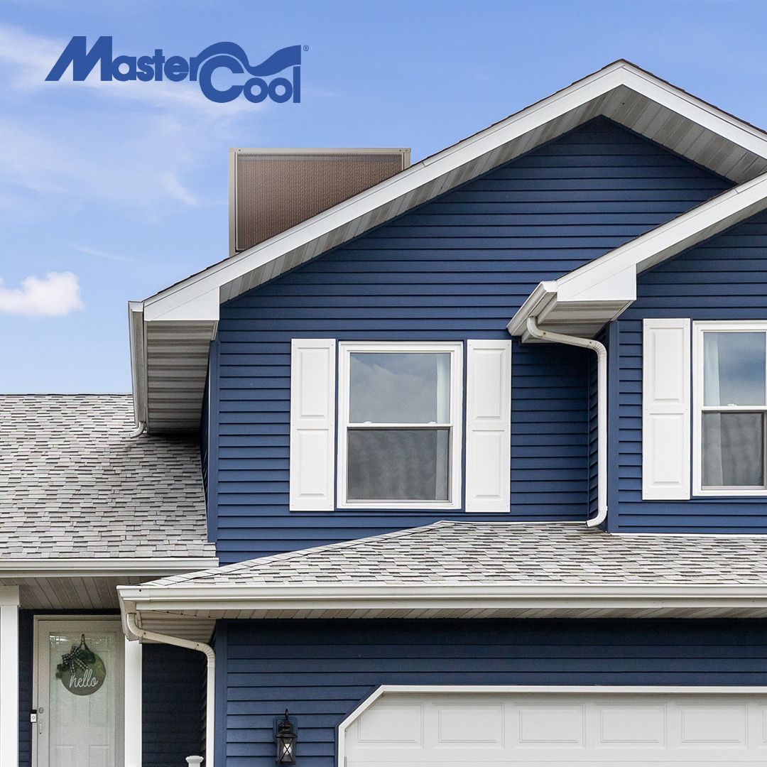 Four white air conditioning units are mounted vertically in a column on a dark, reflective building wall.