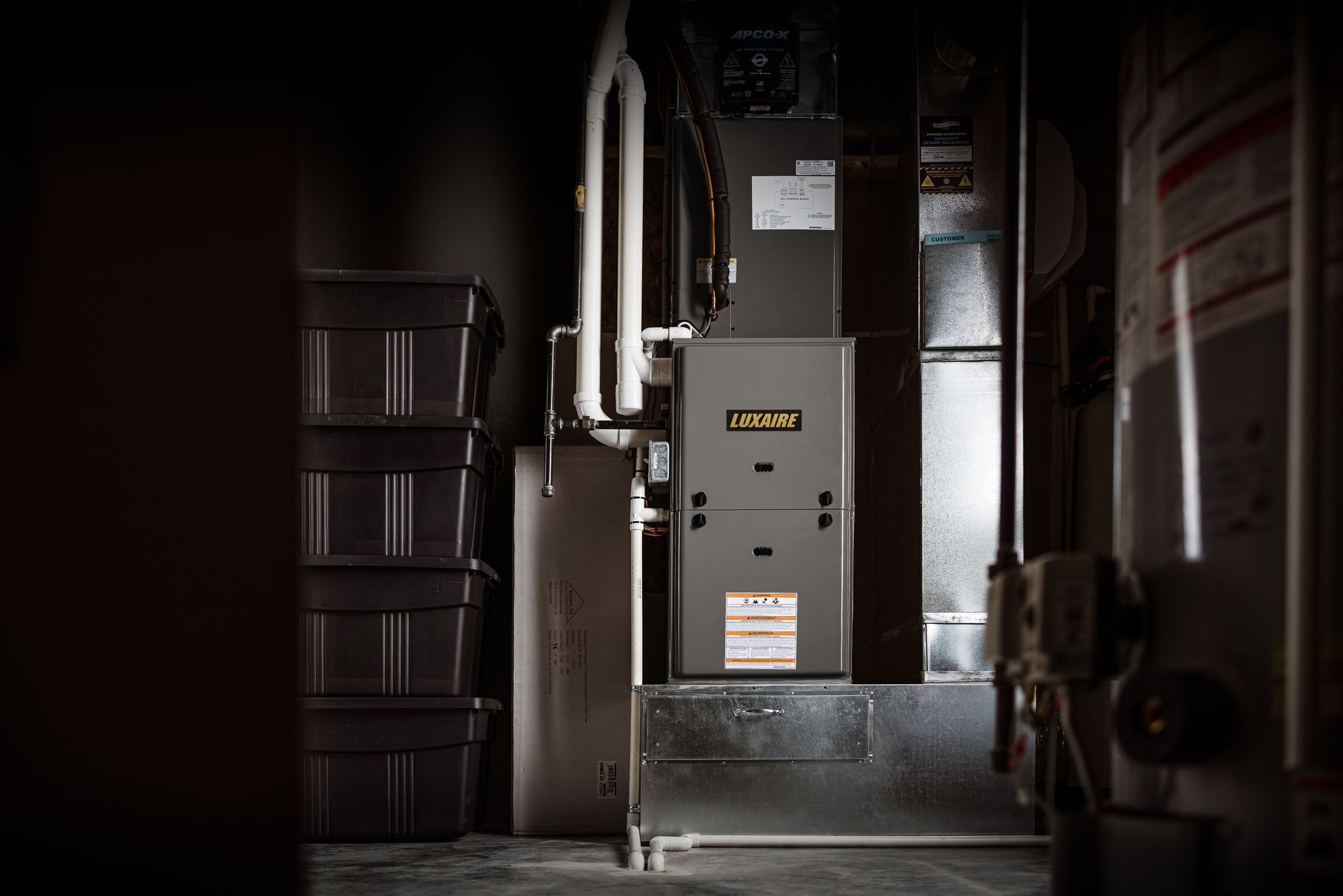 Two Panasonic air conditioning units stacked on a metal frame against a textured, tiled exterior wall.