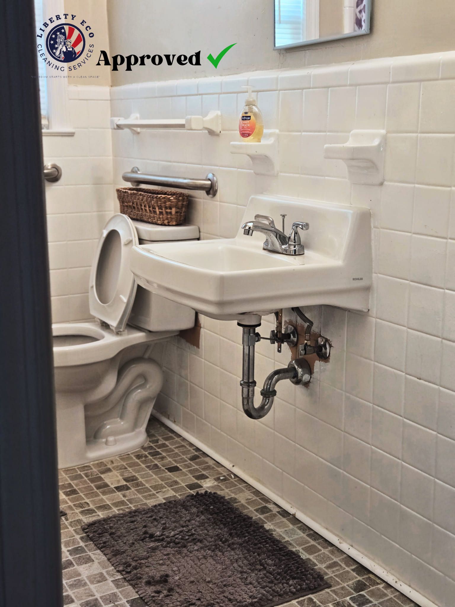 A small bathroom with a toilet, sink, and tiled walls and floor.