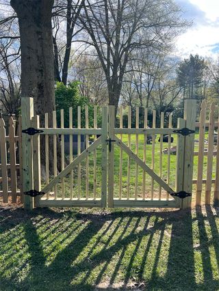 A wooden gate is sitting in the middle of a lush green field.