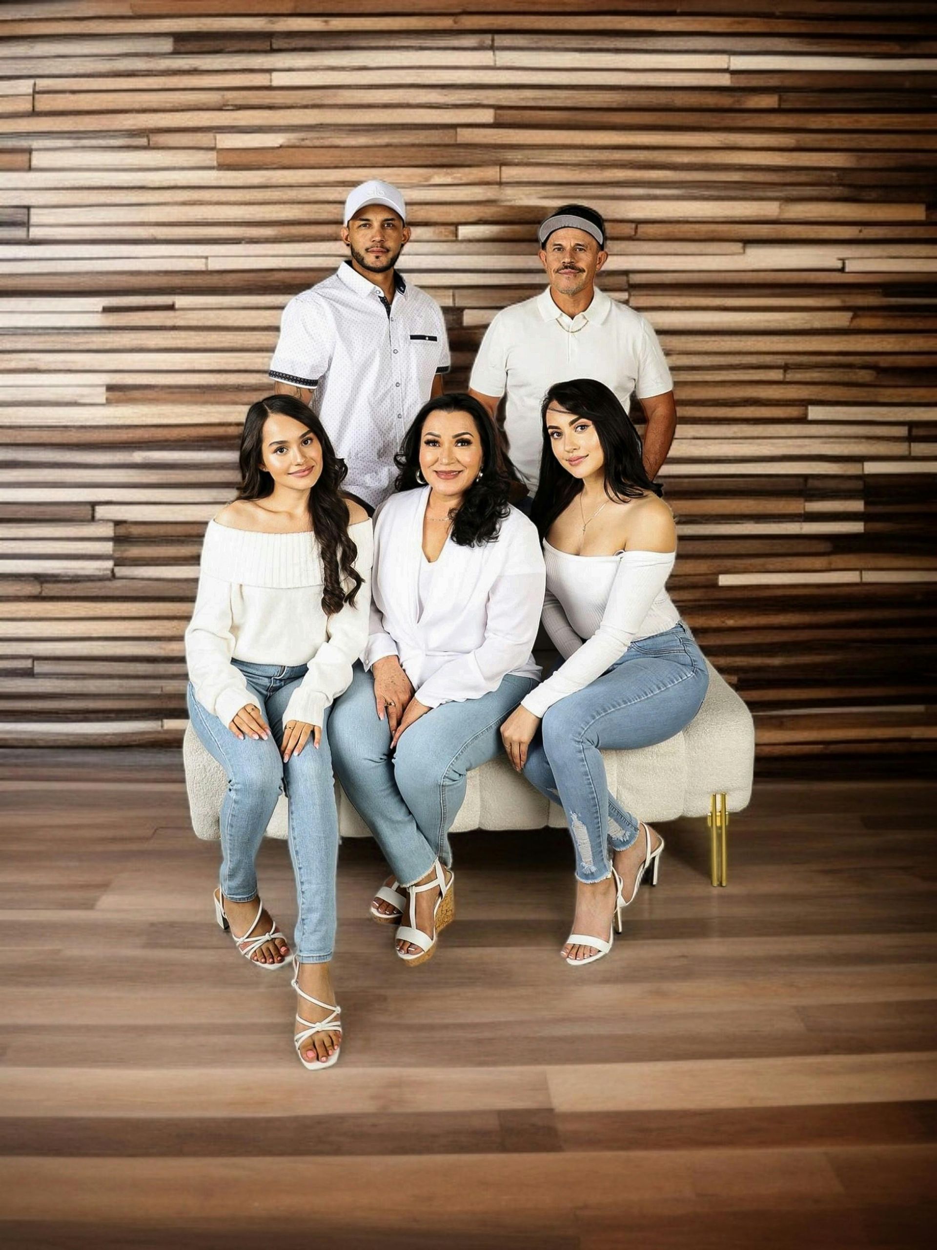 A family is posing for a picture in front of a wooden wall.