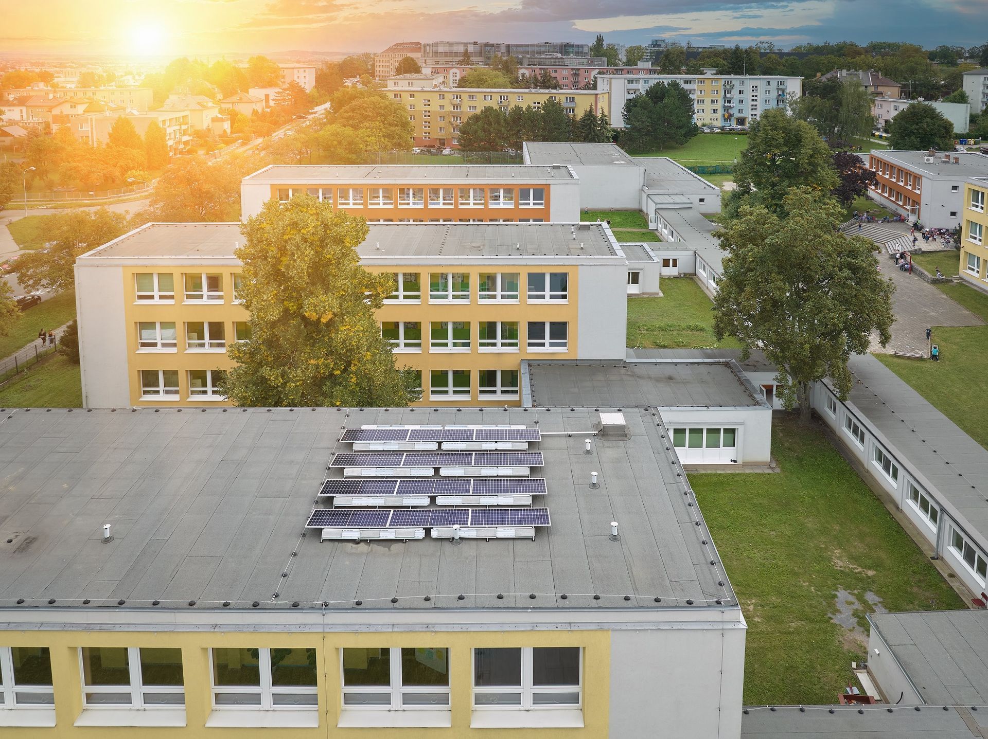 An aerial view of a school building with solar panels on the roof.