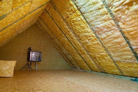 There is a TV on a stand in the attic.