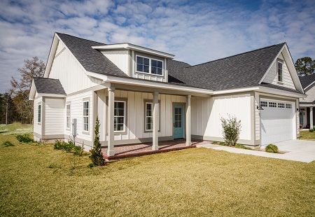 A white house with a blue door and a porch.
