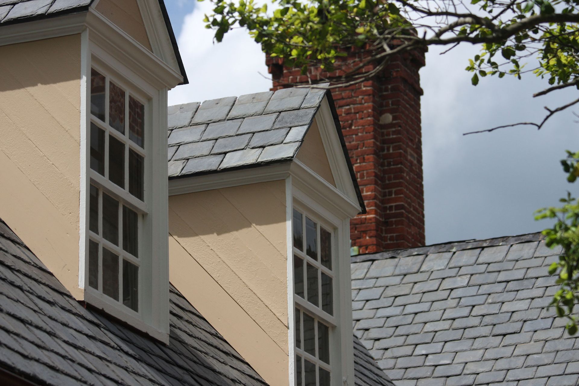 A house with a chimney and two windows on the roof