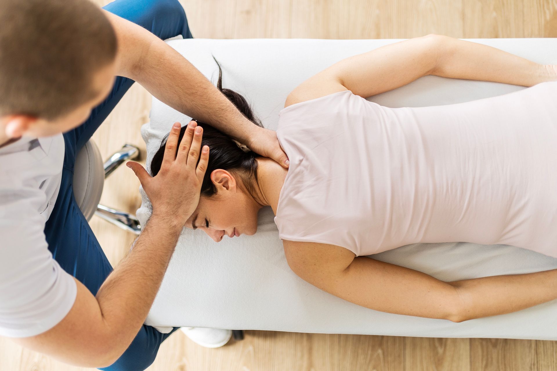 A woman is laying on a bed getting a massage from a man - Mountain Home, AR - Long Chiropractic