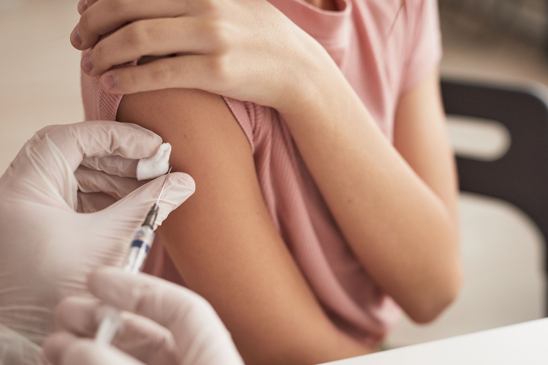 Close-up of a doctor vaccinating a child in a medical clinic.