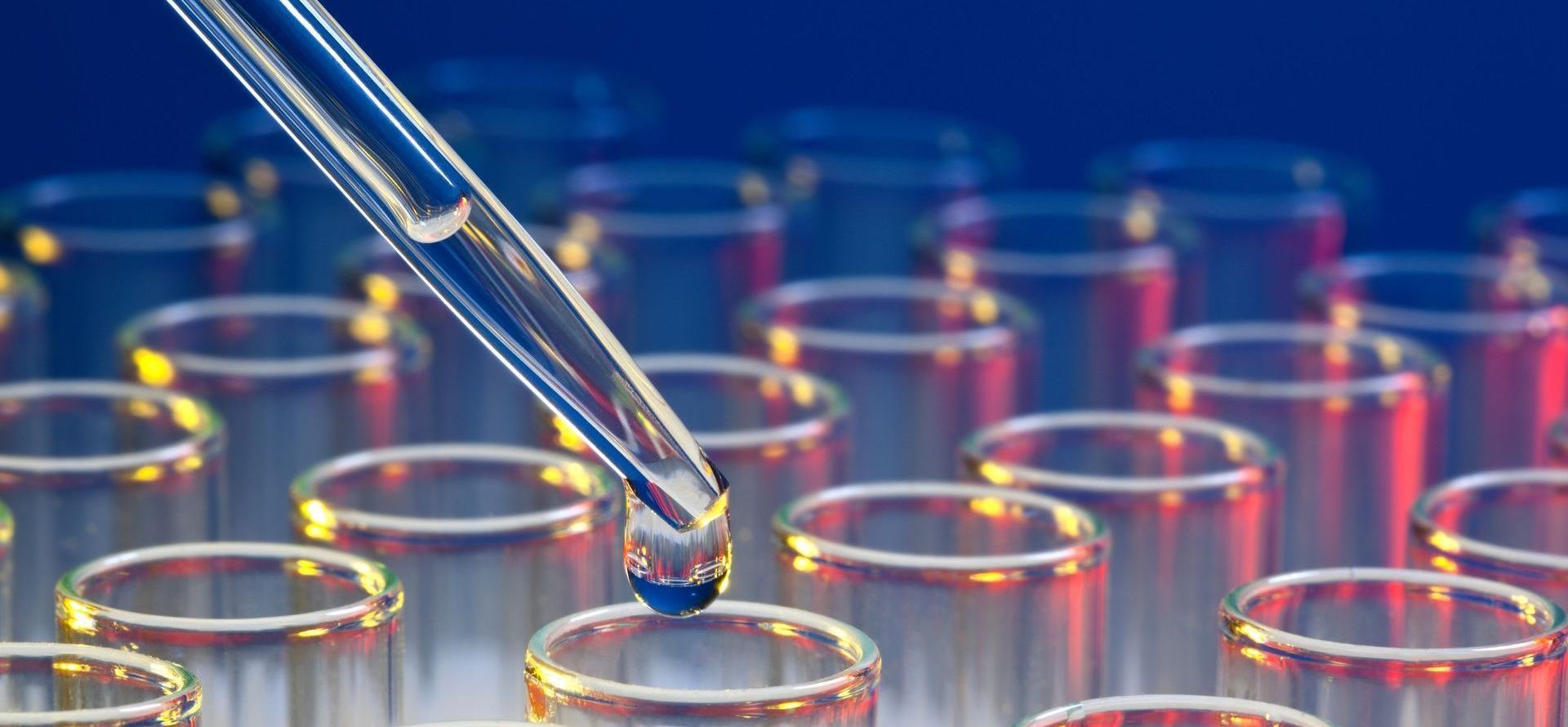 a pipette is dropping liquid into a test tube .