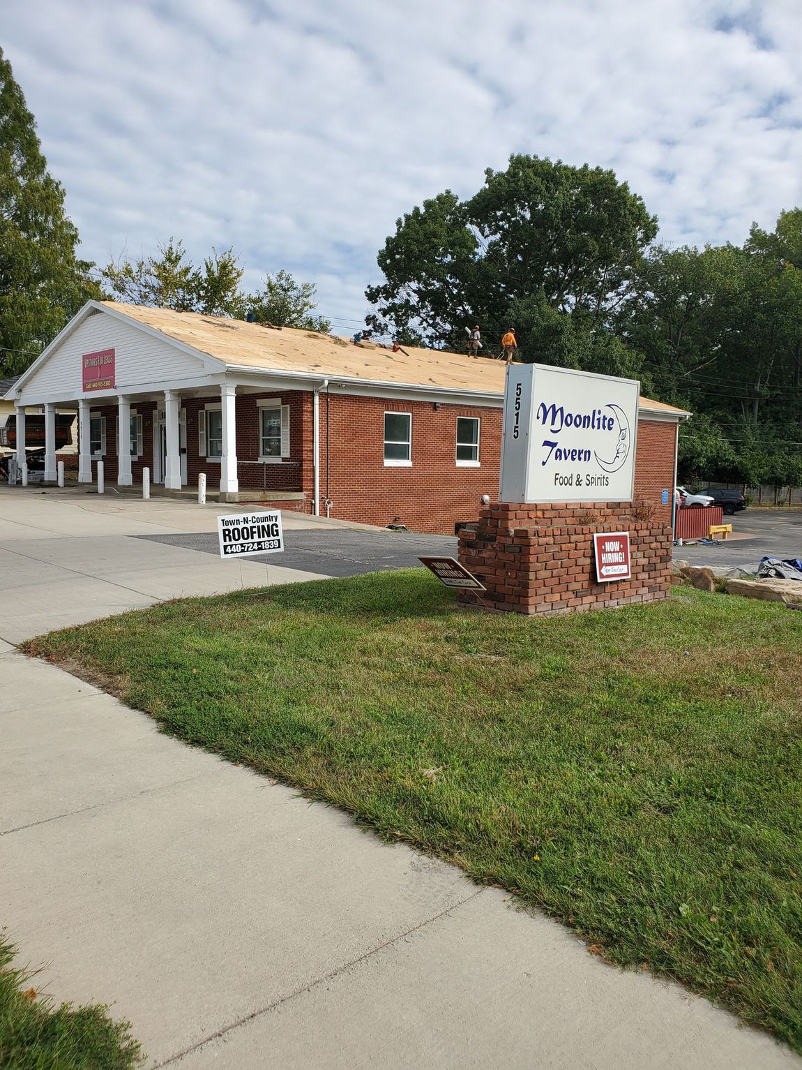 A brick building with a white sign in front of it