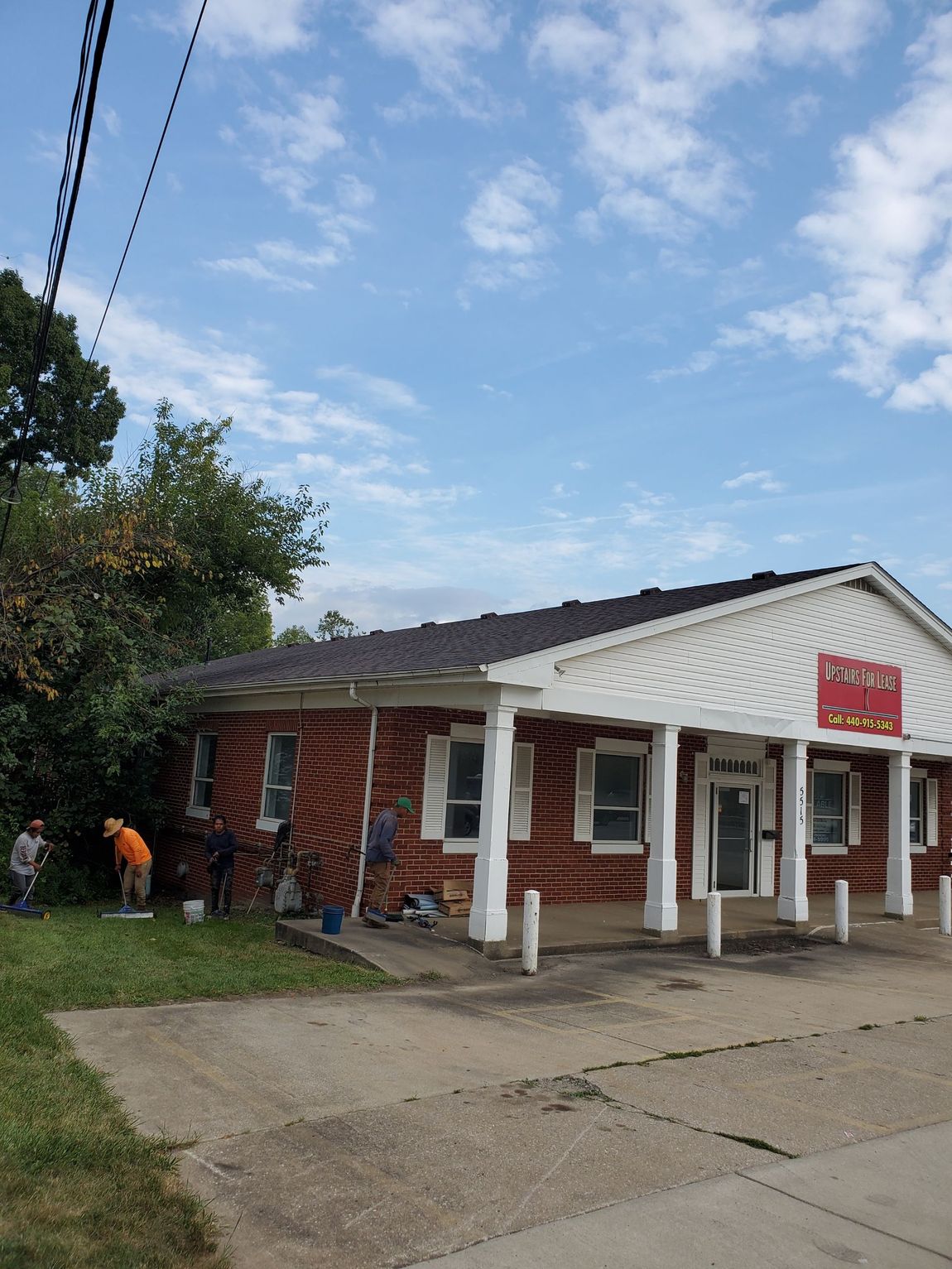 A brick building with a white porch and a sign that says ' u.s. post office ' on it