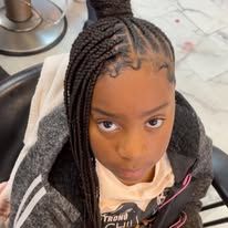 Young Black girl with braided hair and hoodie, looking up.