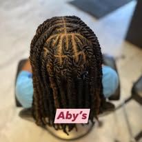 Close-up of dark, intricately twisted locs styled in a grid pattern, with 