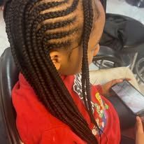 Young person with braided hair wearing a red jacket, looking down at a phone.