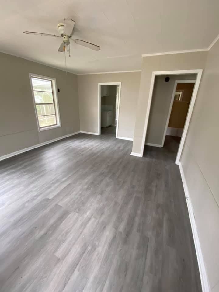 A living room with hardwood floors and a ceiling fan.
