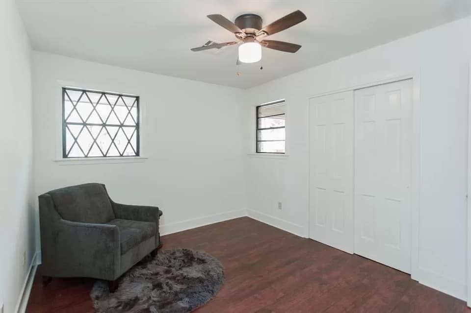 There is a chair and a ceiling fan in the room.