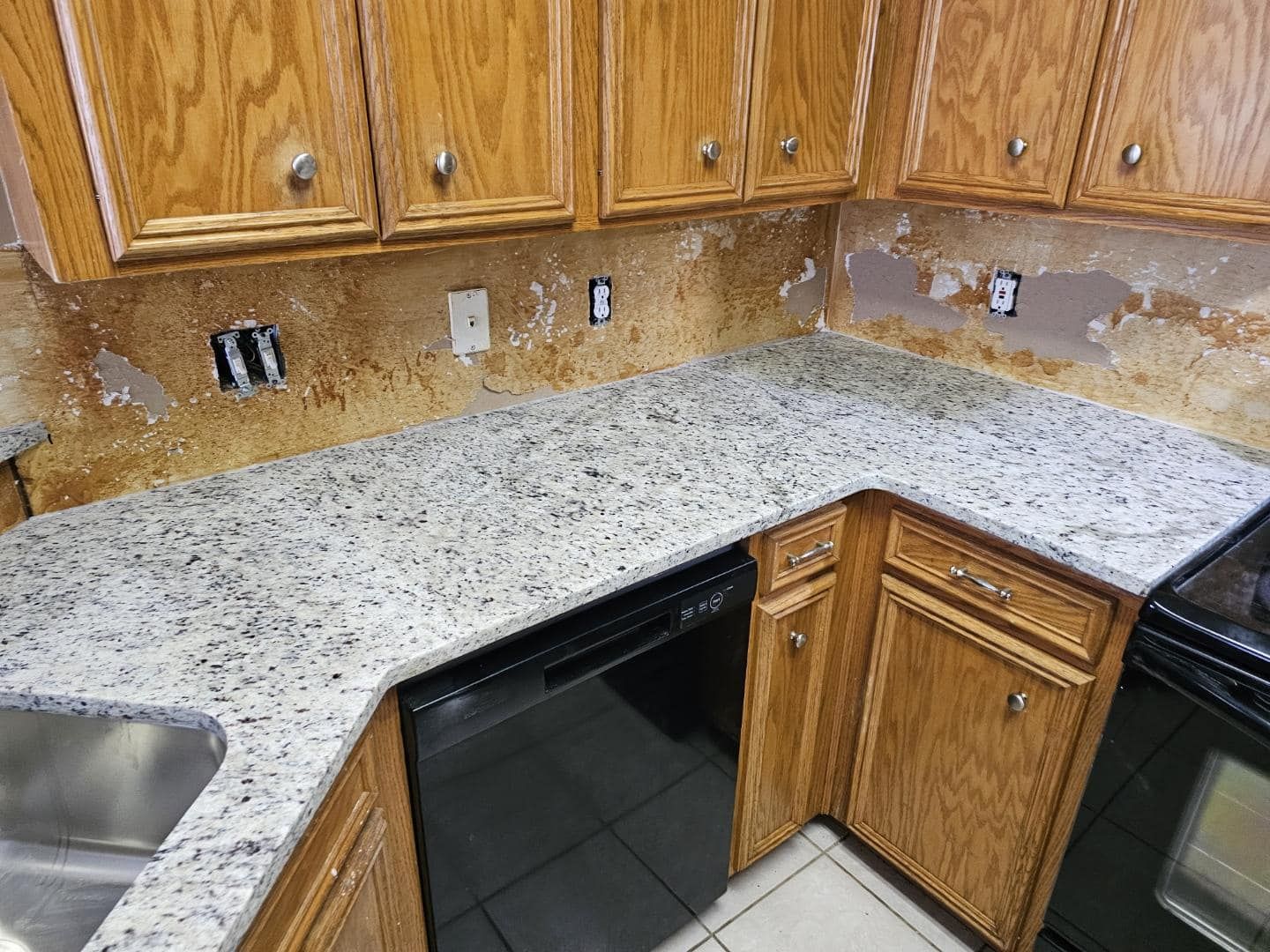 A kitchen with granite counter tops and wooden cabinets