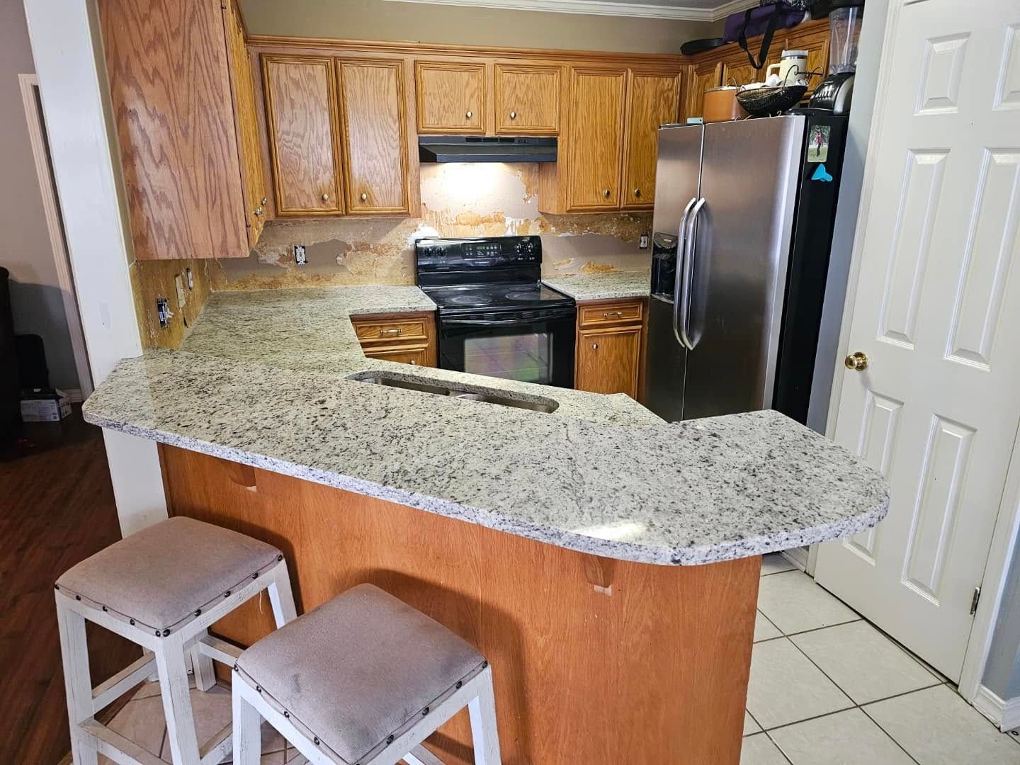 A kitchen with granite counter tops and stools