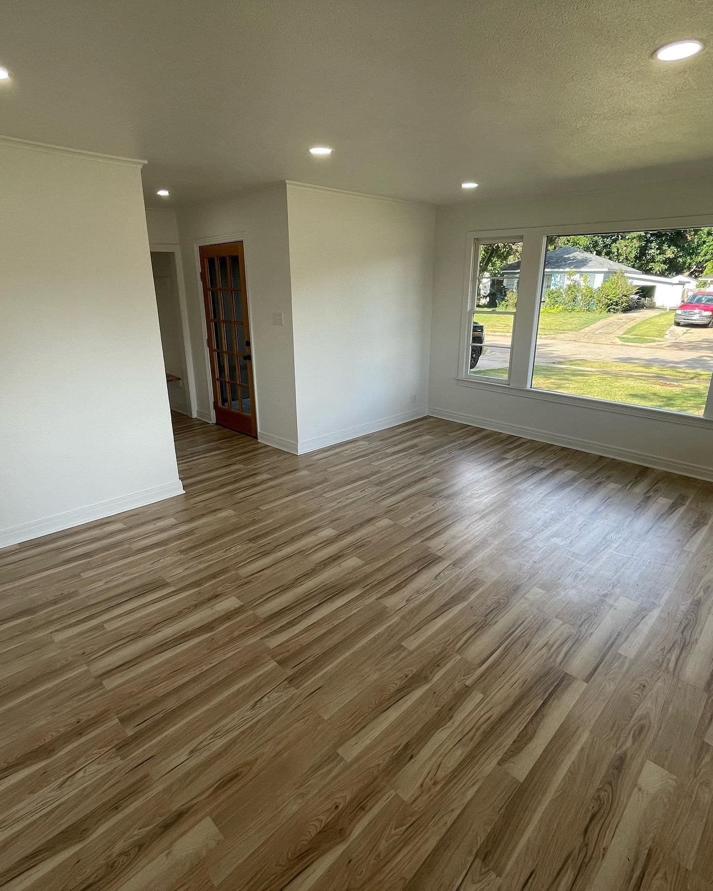 A living room with hardwood floors and white walls.