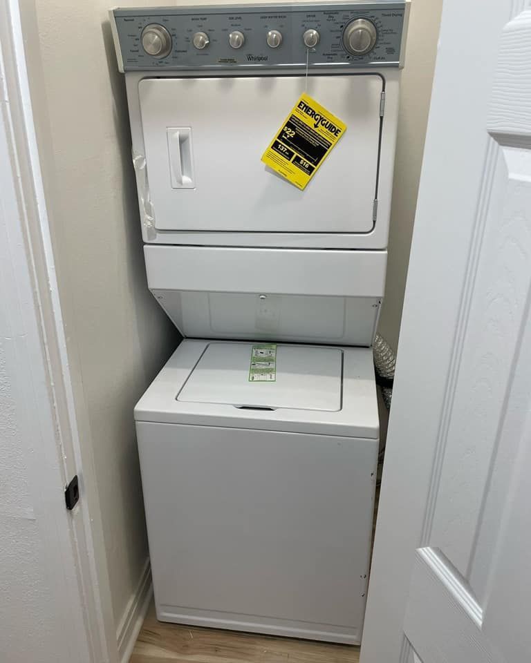 A washer and dryer are stacked on top of each other in a closet.