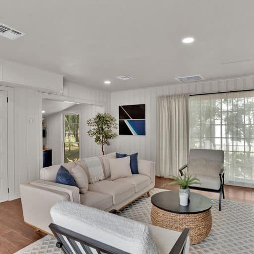 A living room with a couch , chairs , and a table.