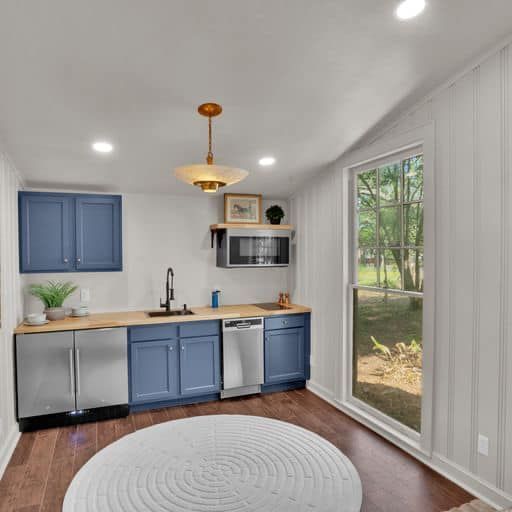 A kitchen with blue cabinets and stainless steel appliances