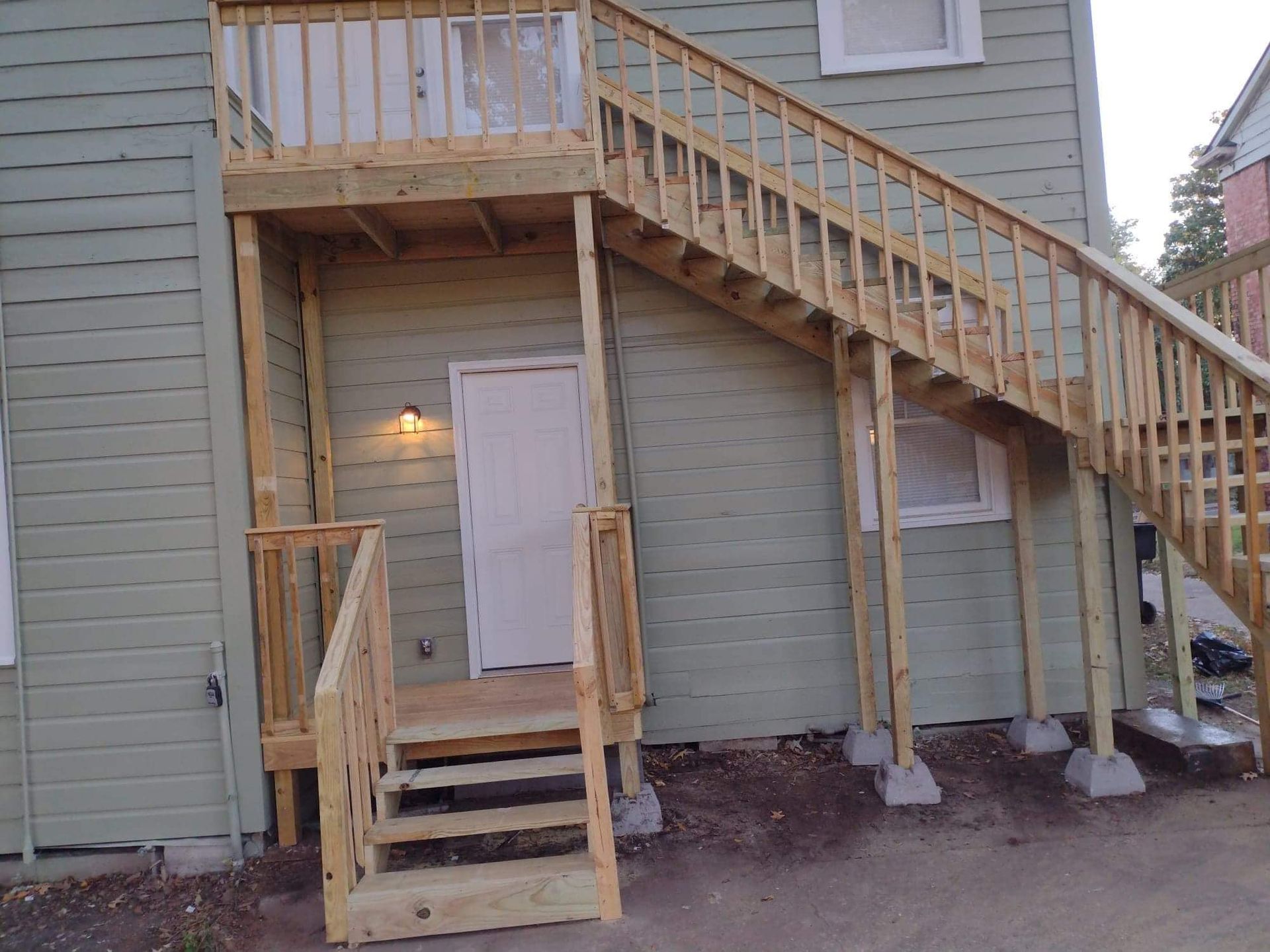 A house with a wooden deck and stairs leading up to it.