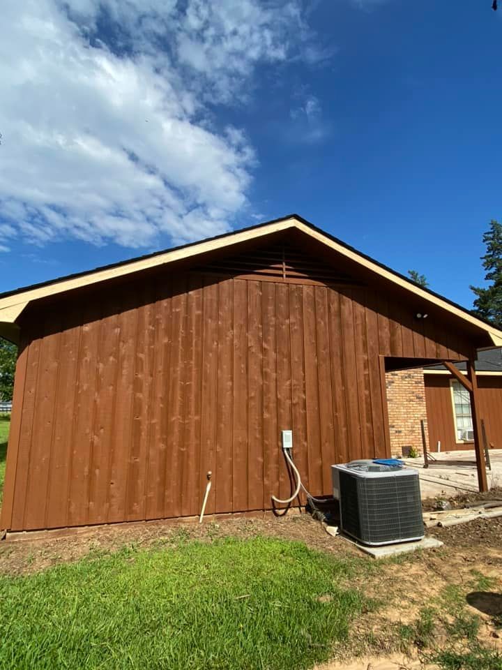 A brown house with a air conditioner on the side of it.