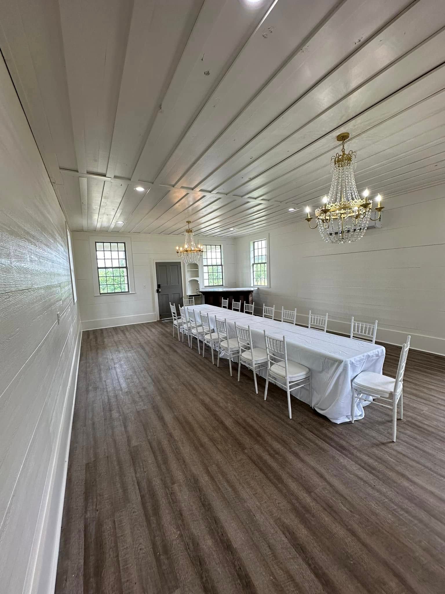 A large room with a long table and chairs and a chandelier.