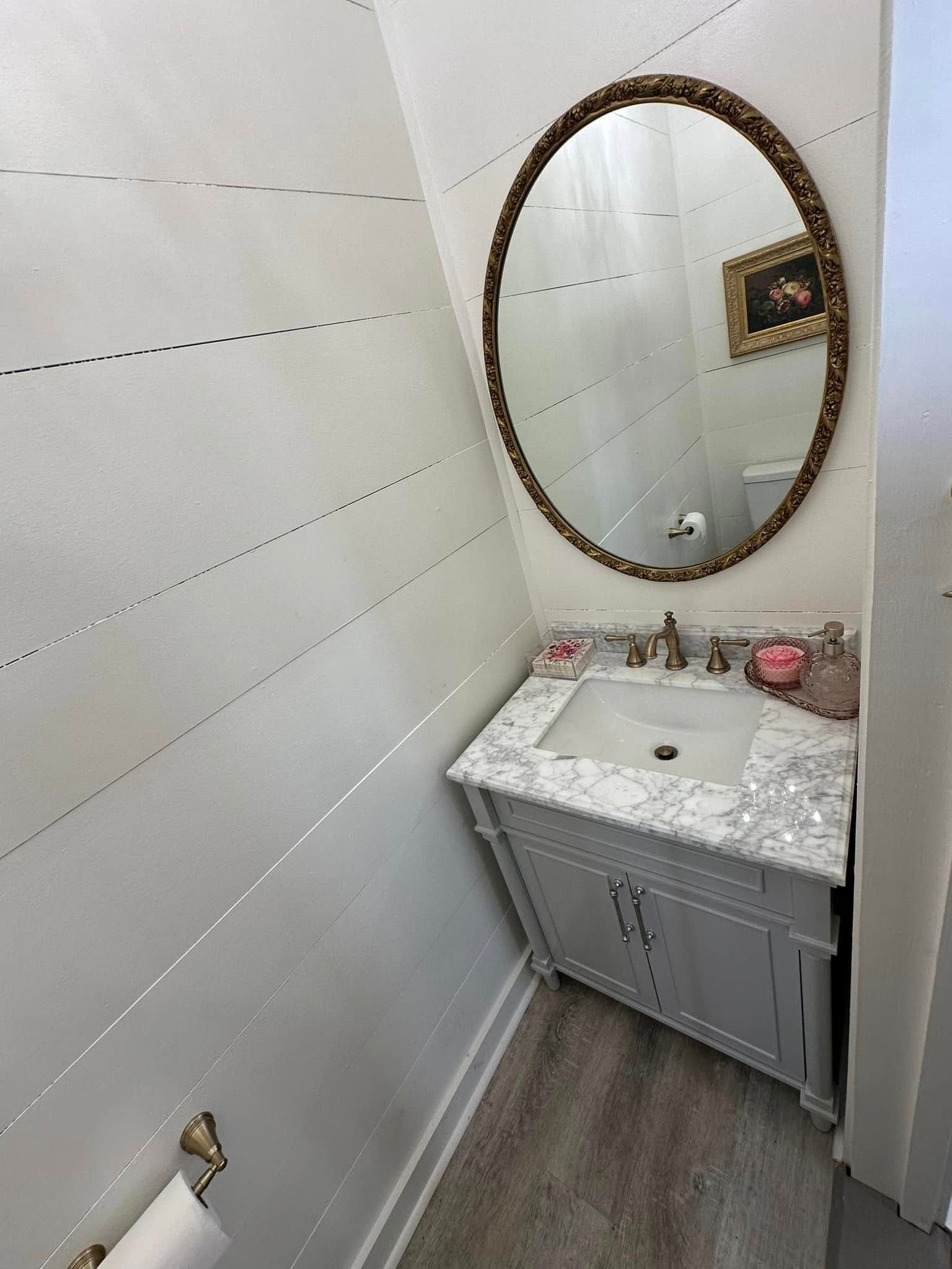 A bathroom with a sink , mirror and toilet.