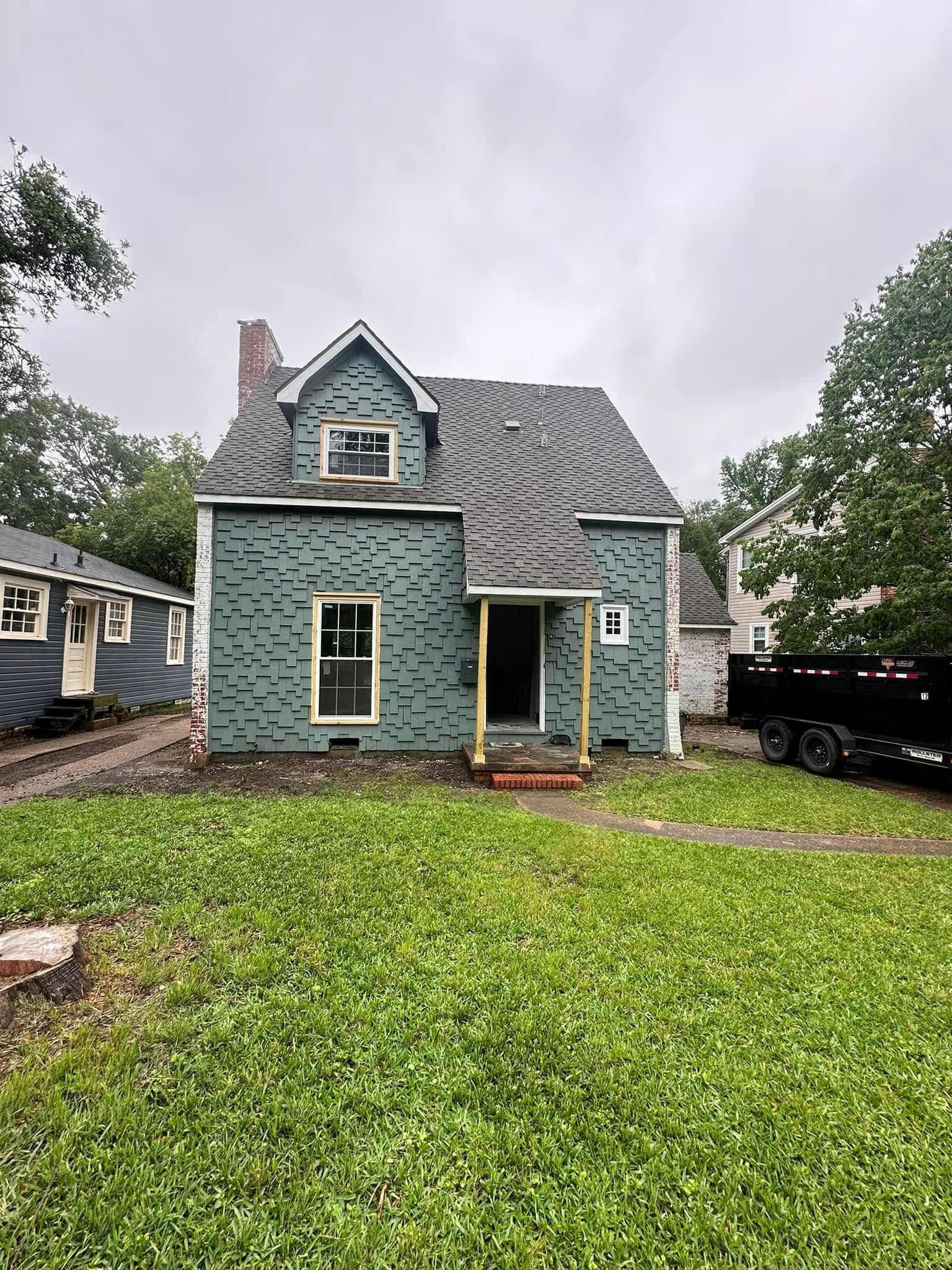 A house is being remodeled and a truck is parked in front of it.
