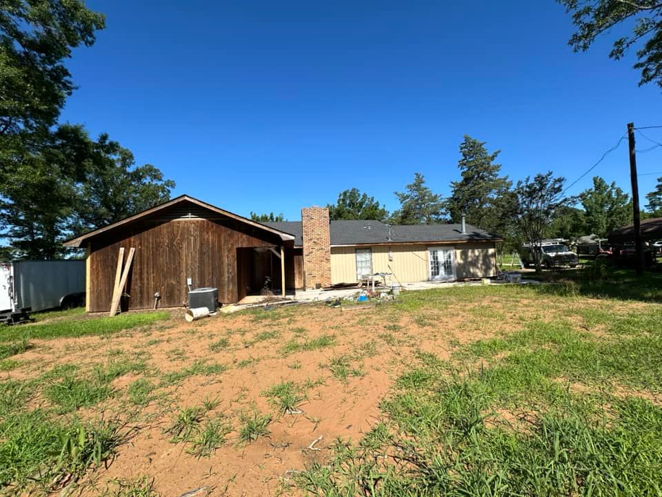 A house is sitting in the middle of a grassy field.