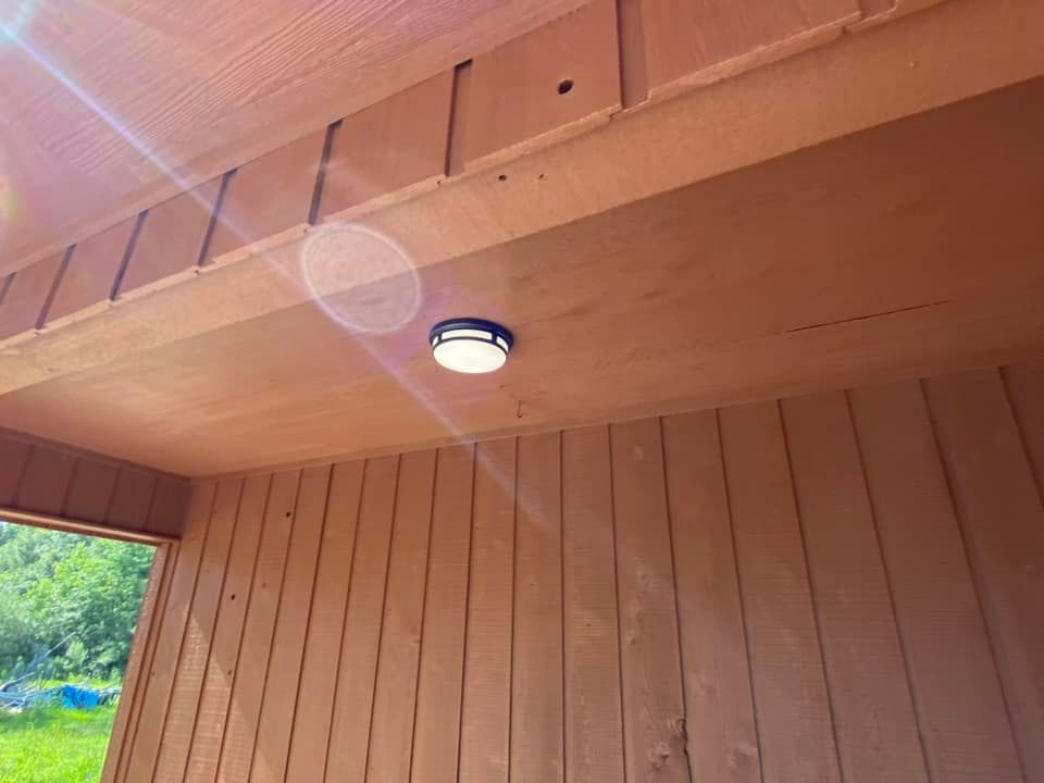A light is hanging from the ceiling of a wooden building.
