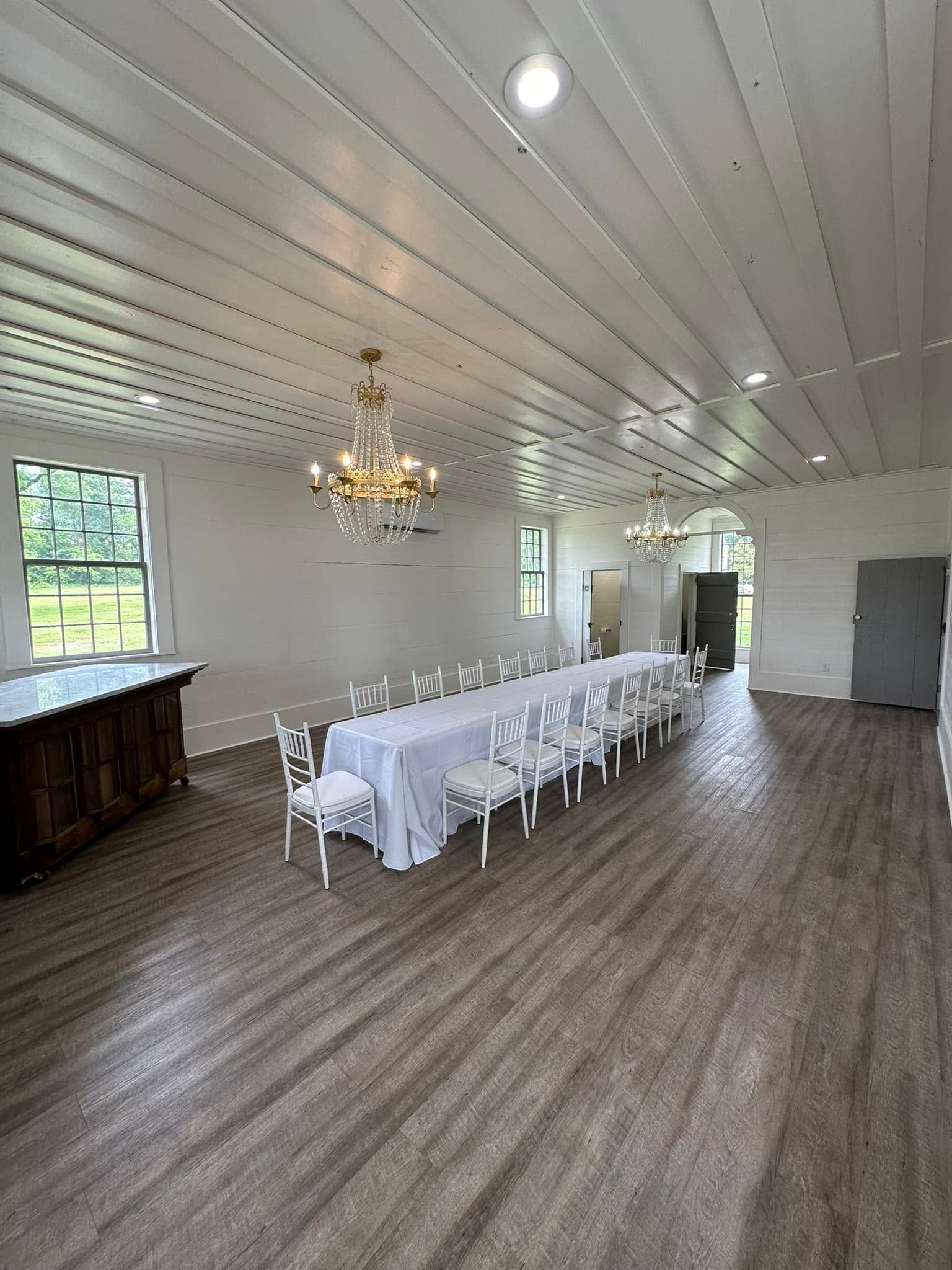 A large room with a long table and chairs in it.