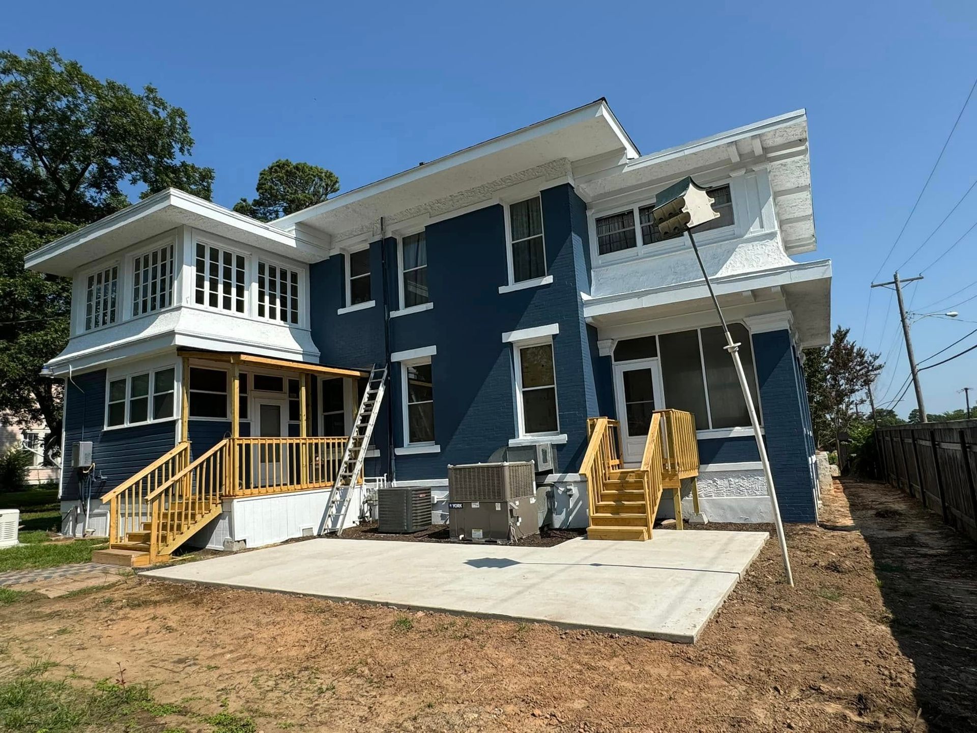 A blue and white house with stairs and chairs in front of it