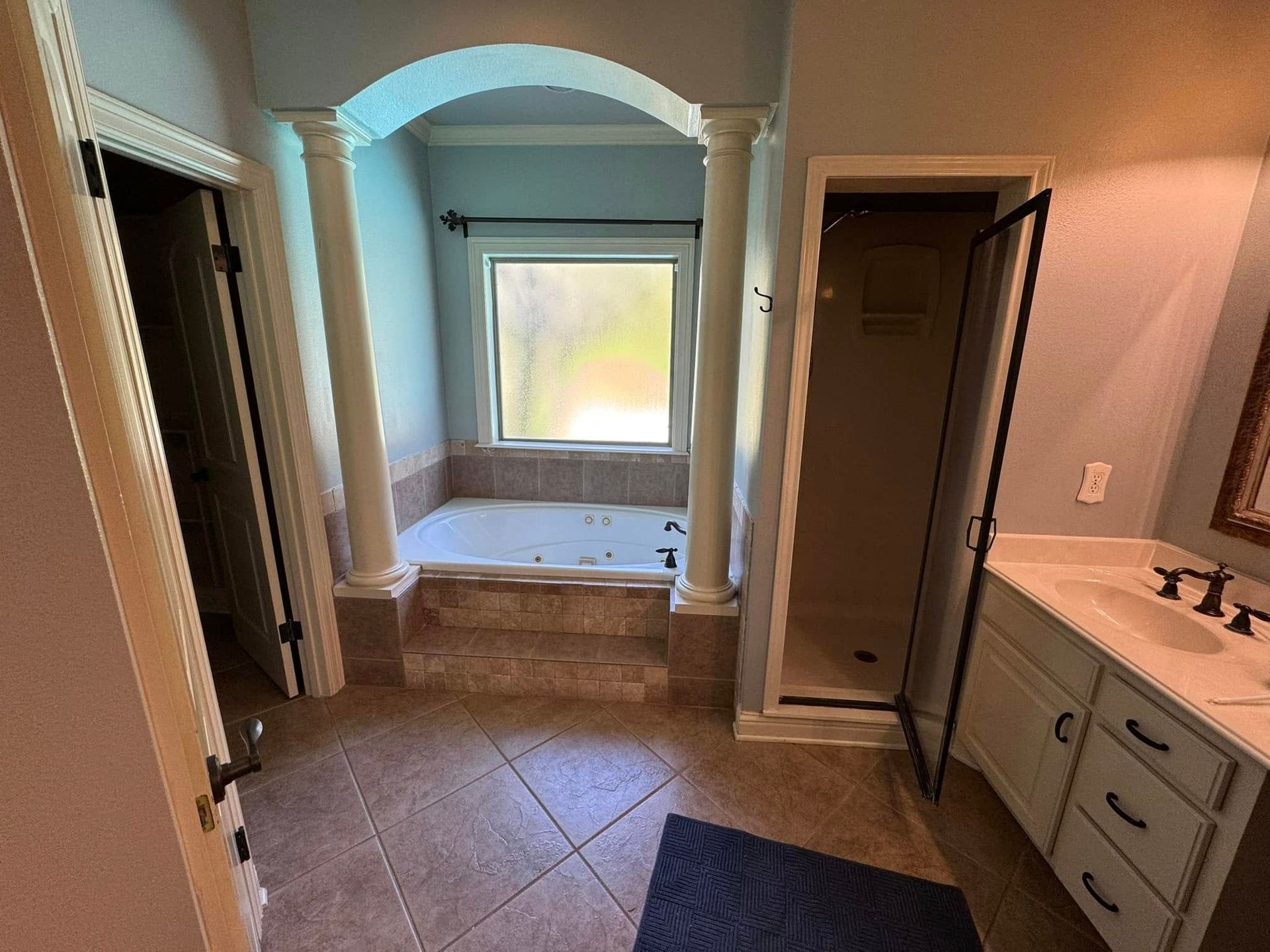 A bathroom with a jacuzzi tub , sink , and shower.