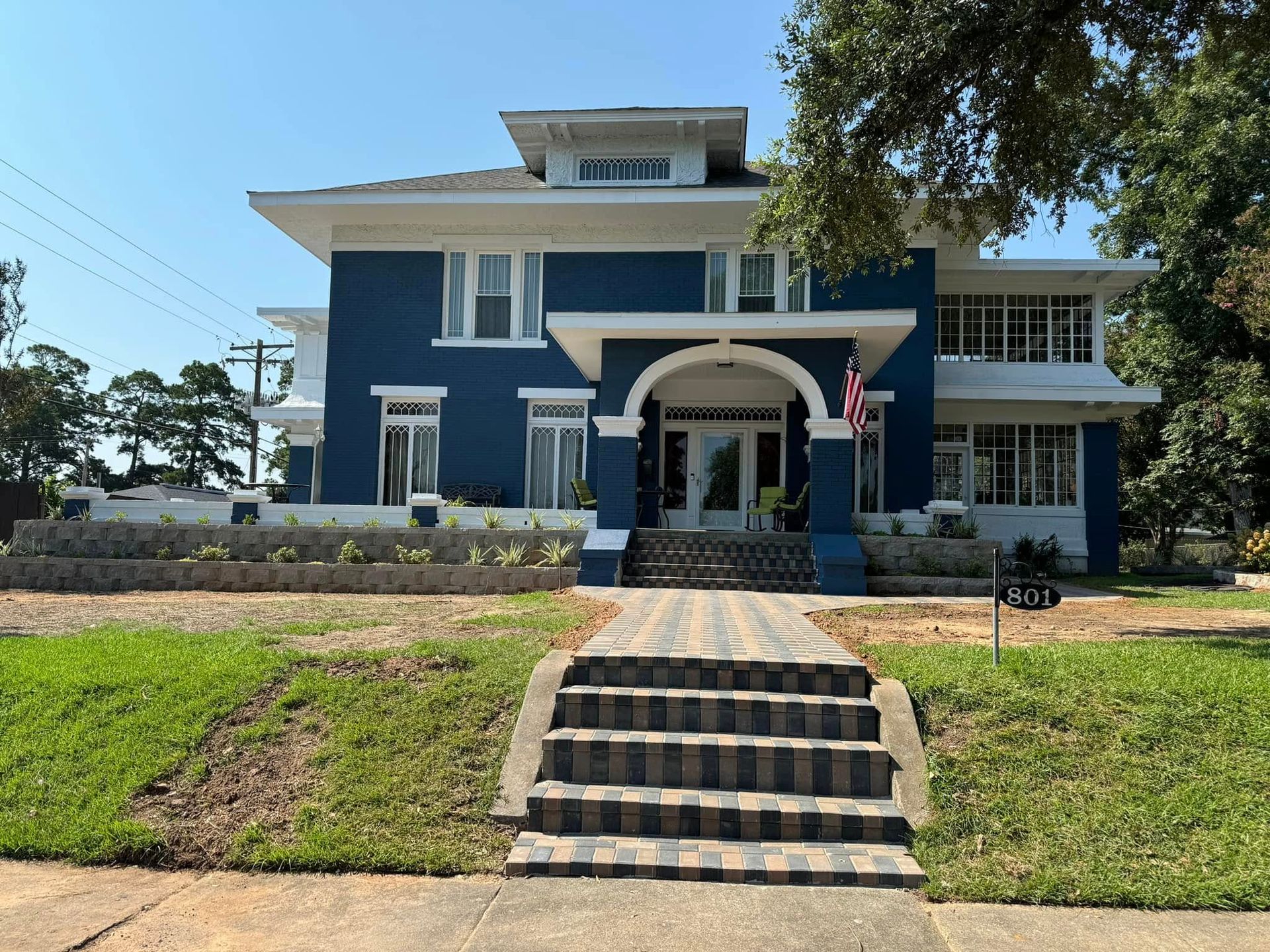 A large blue and white house with stairs leading up to it
