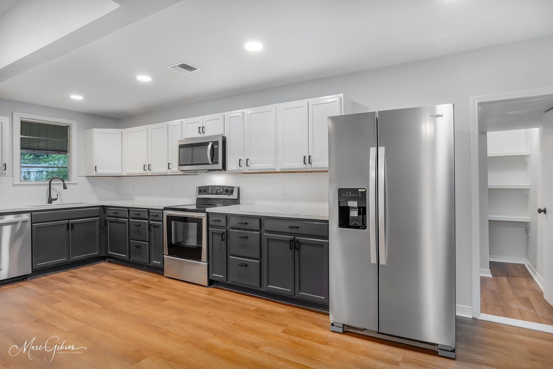 A kitchen with stainless steel appliances and gray cabinets.