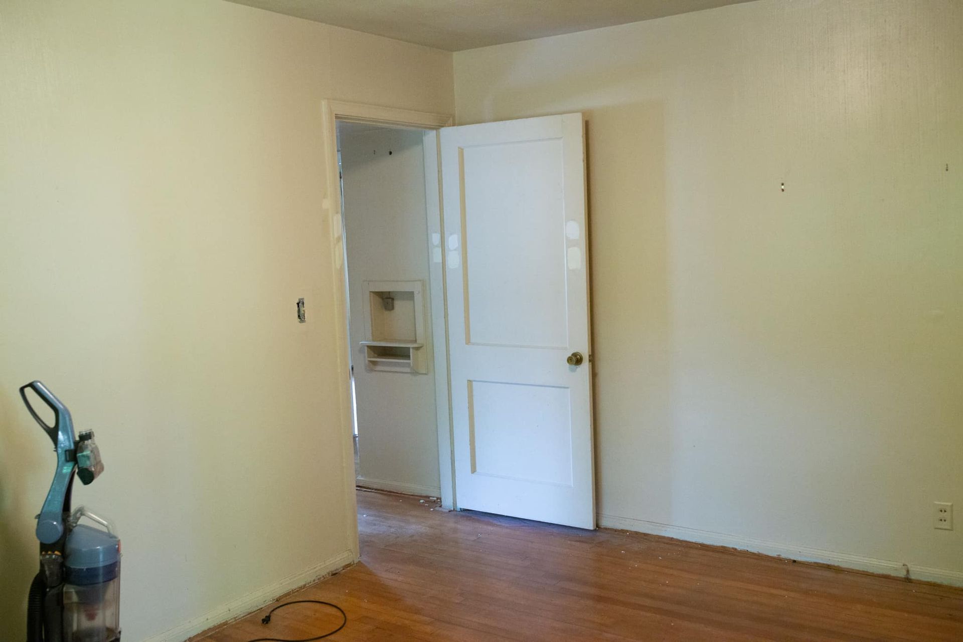 There is a vacuum cleaner in the corner of the room.