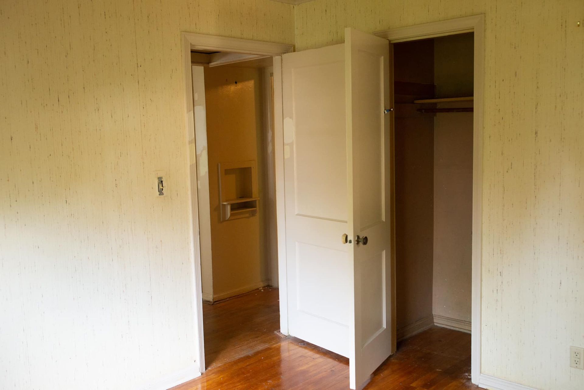 An empty room with two doors open and a closet.