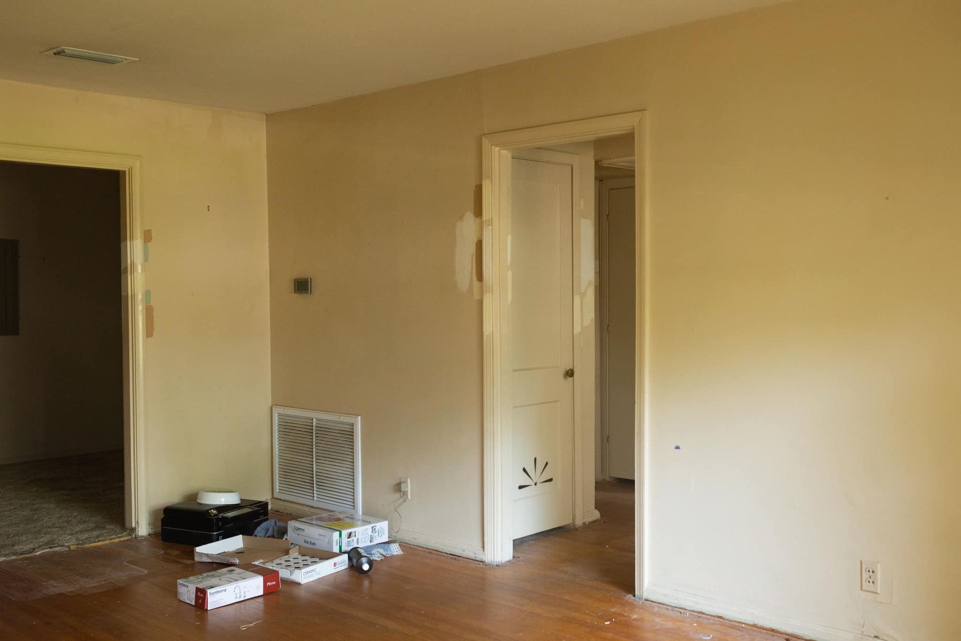An empty room with a wooden floor and white walls