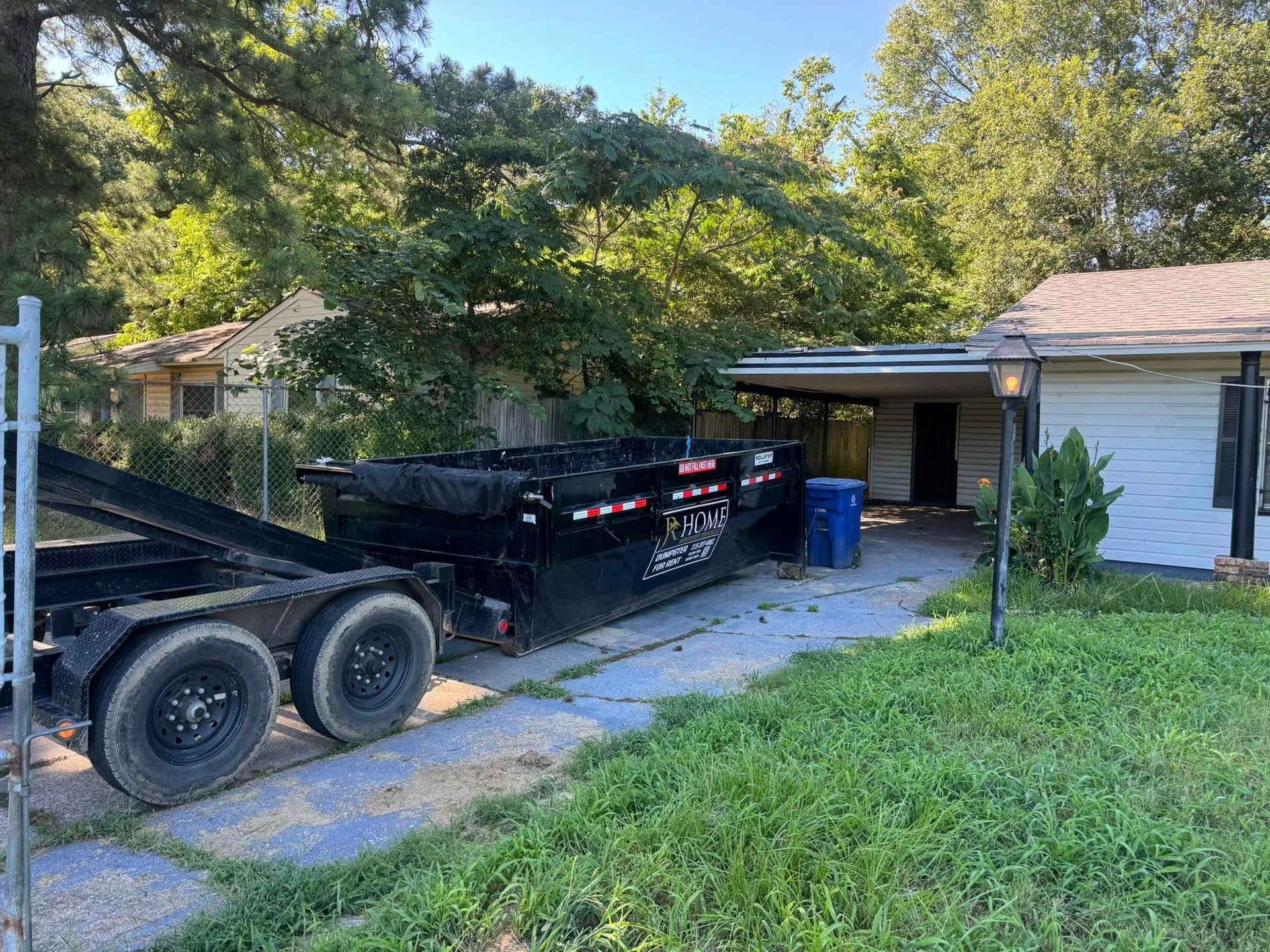A dumpster is parked in front of a house.