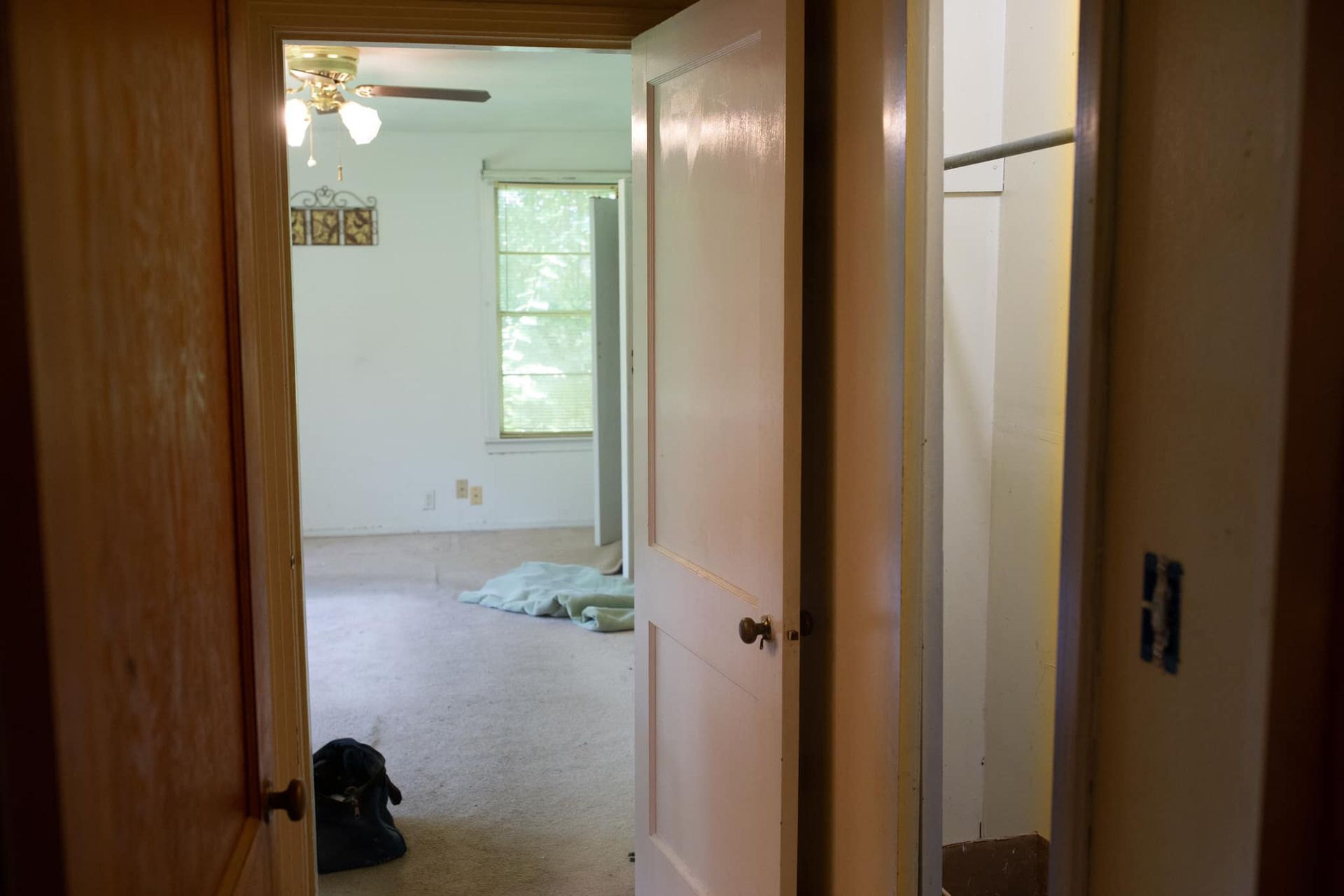 A doorway leading to a bedroom with a ceiling fan.