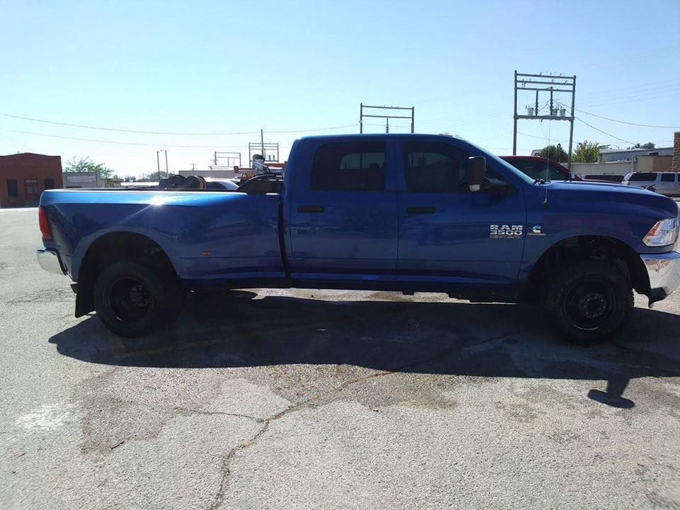 Blue pickup truck parked in a lot under a clear sky