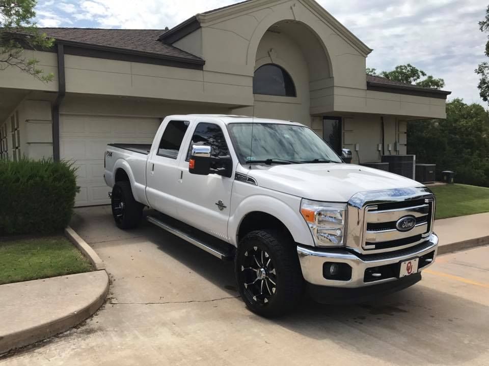 White Ford pickup truck parked in a driveway in front of a suburban house