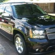 Black SUV parked outdoors in daylight, front-left view