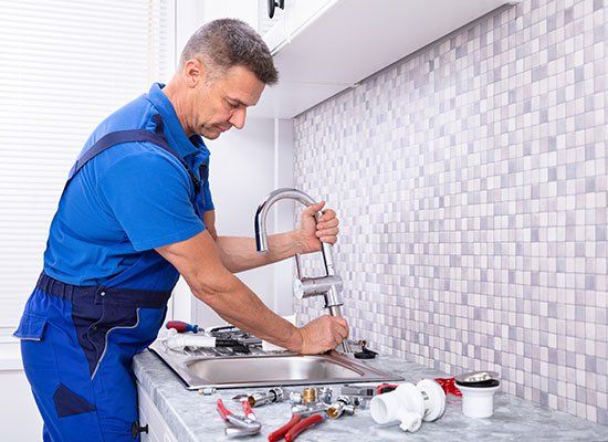 Worker Fixing Water Tap — Hatfield, MA — AM/PM Plumbing & Heating