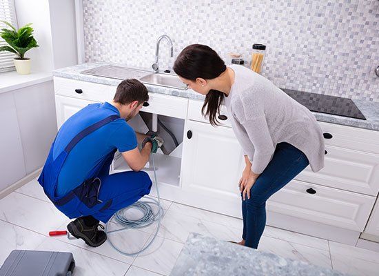 Male Plumber Cleaning Clogged Sink — Hatfield, MA — AM/PM Plumbing & Heating