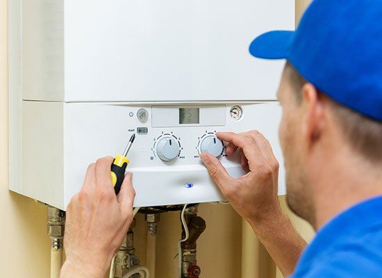Worker Fixing Heater — Hatfield, MA — AM/PM Plumbing & Heating