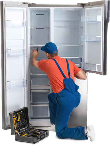 Technician kneeling by open refrigerator, using a screwdriver to repair the interior.