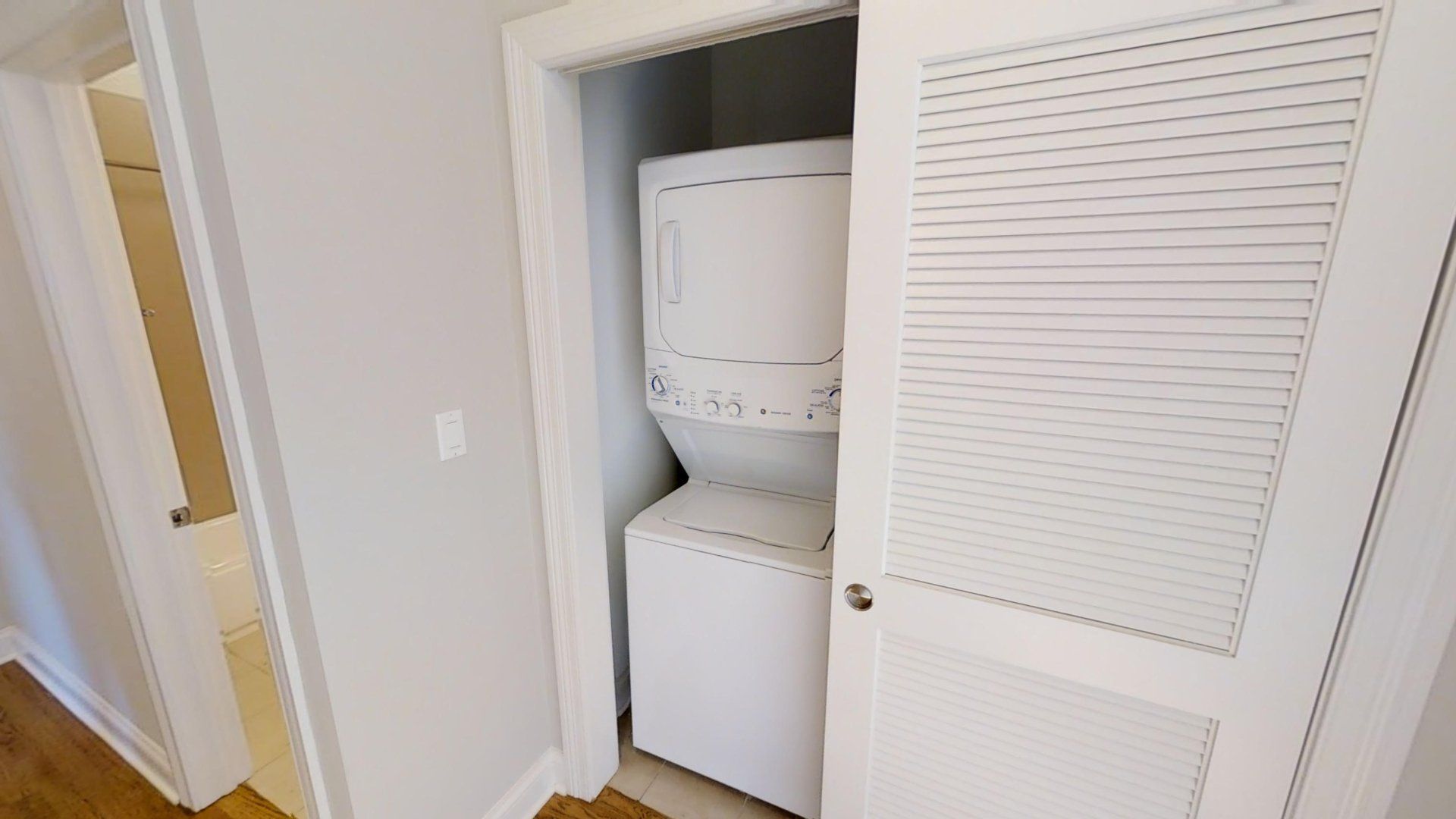 A washer and dryer are stacked in a closet.